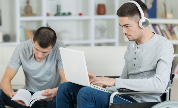 Image: two individuals volunteering on laptops