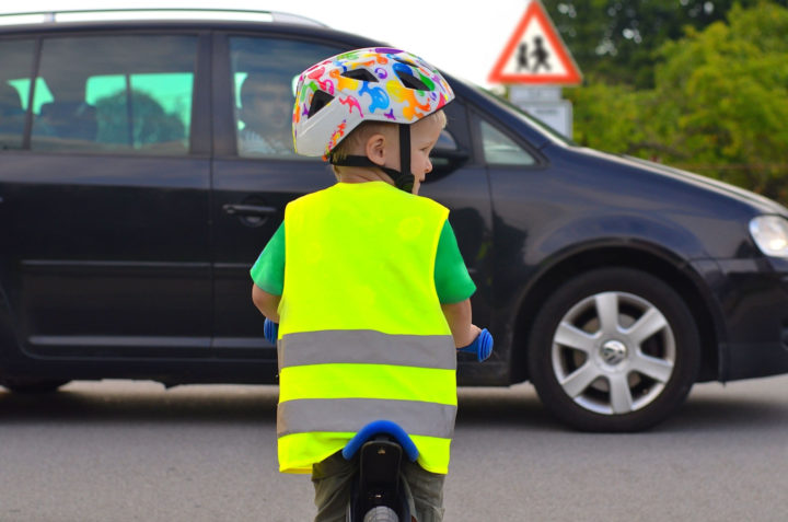 Child in high visibility jacket on a bicycle