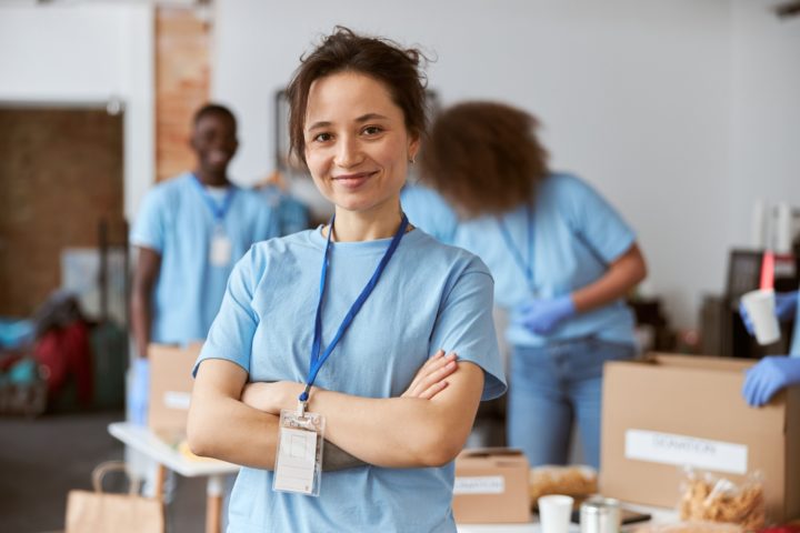 Woman stands in front of group of people in blue t-shirts