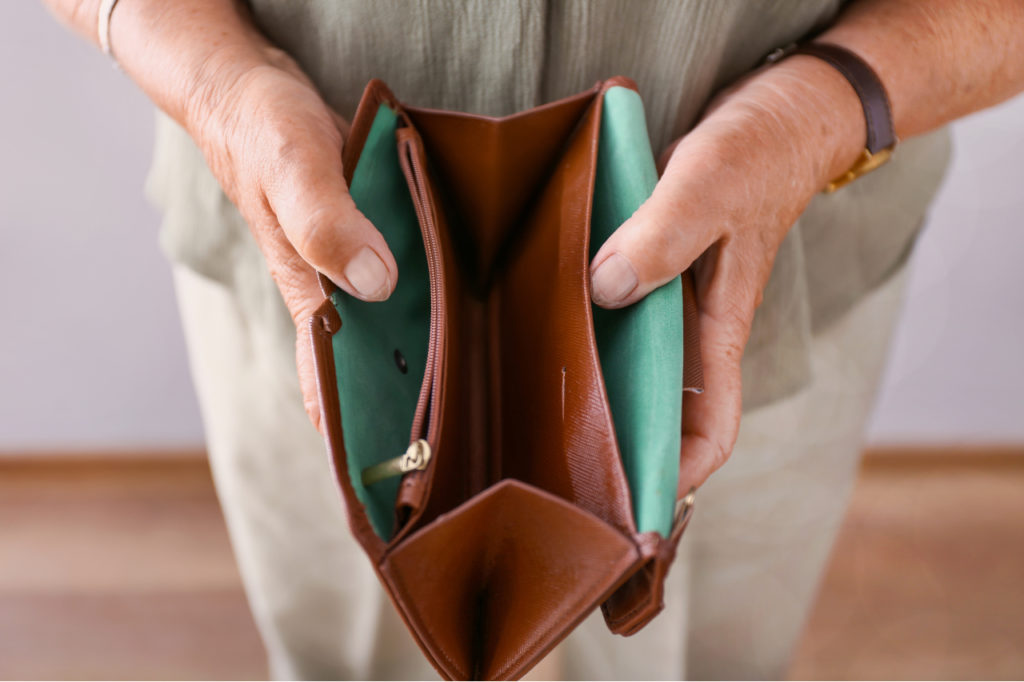 A pair of hands holds open an empty wallet