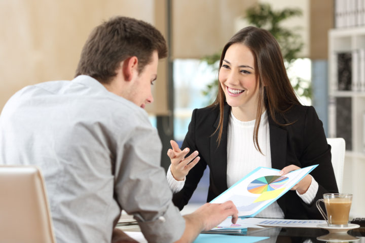 Woman shows a man a piece of paper with a chart