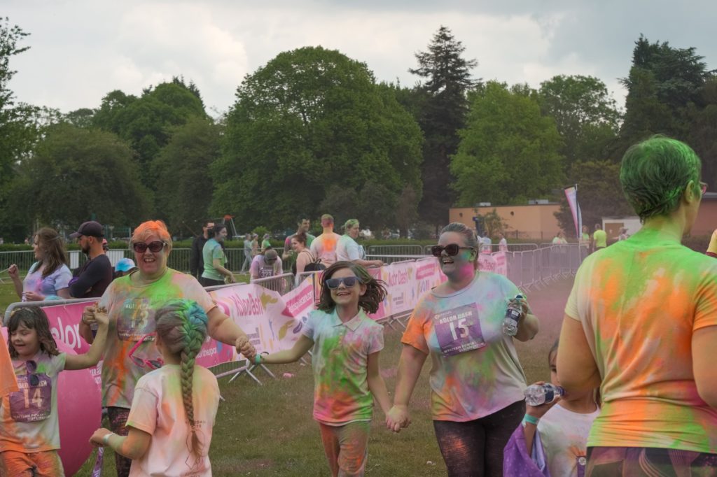 Smiling happy people covered in paint at a charity fun run event