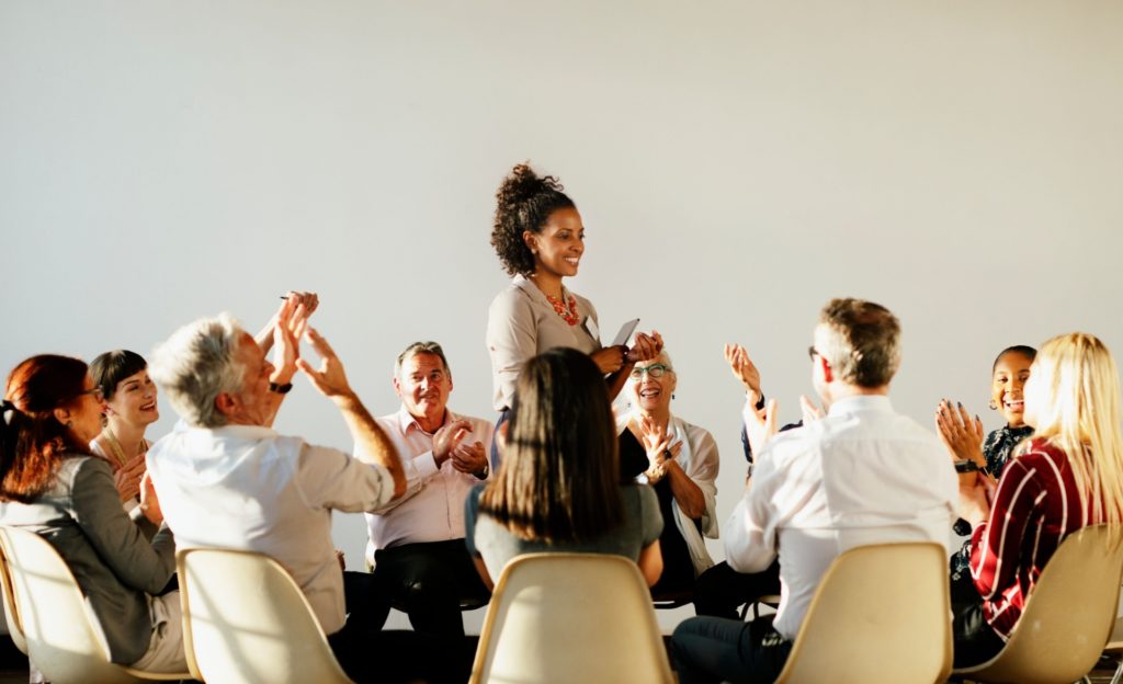 People sat in a circle of chairs talking