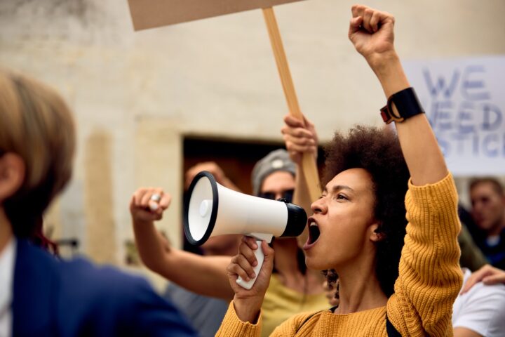 Woman shouting into a microphone at a protest